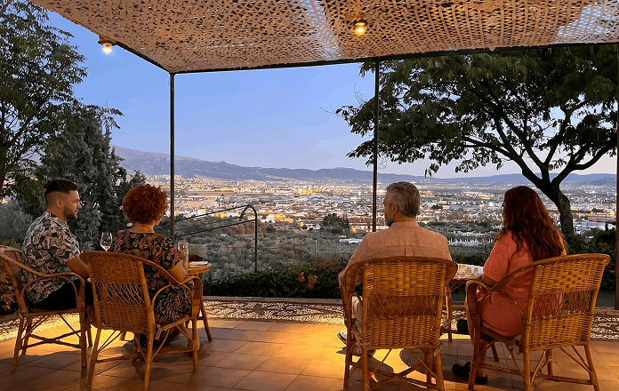 Personas cenando en la terraza al anochecer