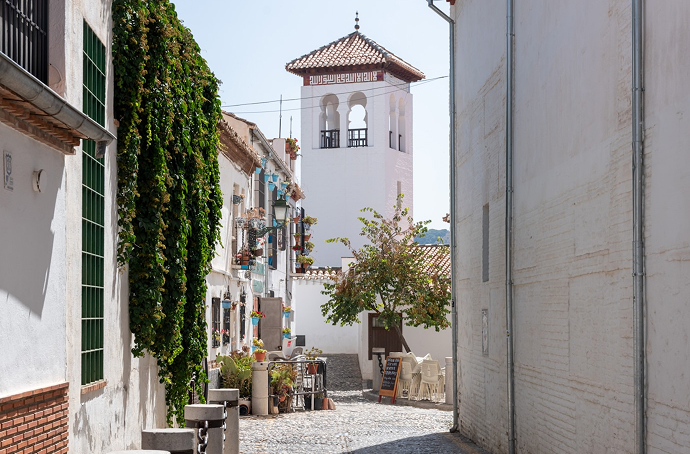 Calle del Albaicín Calle con torre al fondo estilo andalúz