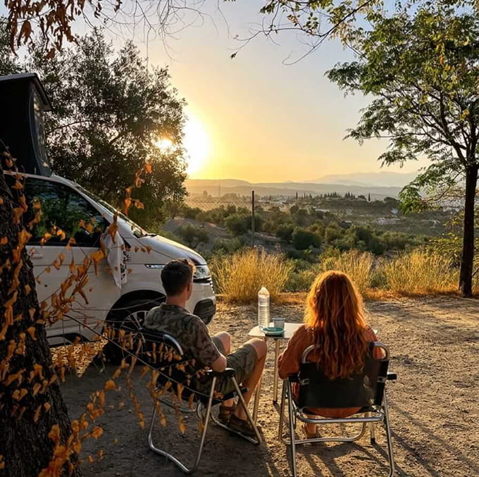 Una pareja sentada disfrutando del atardecer